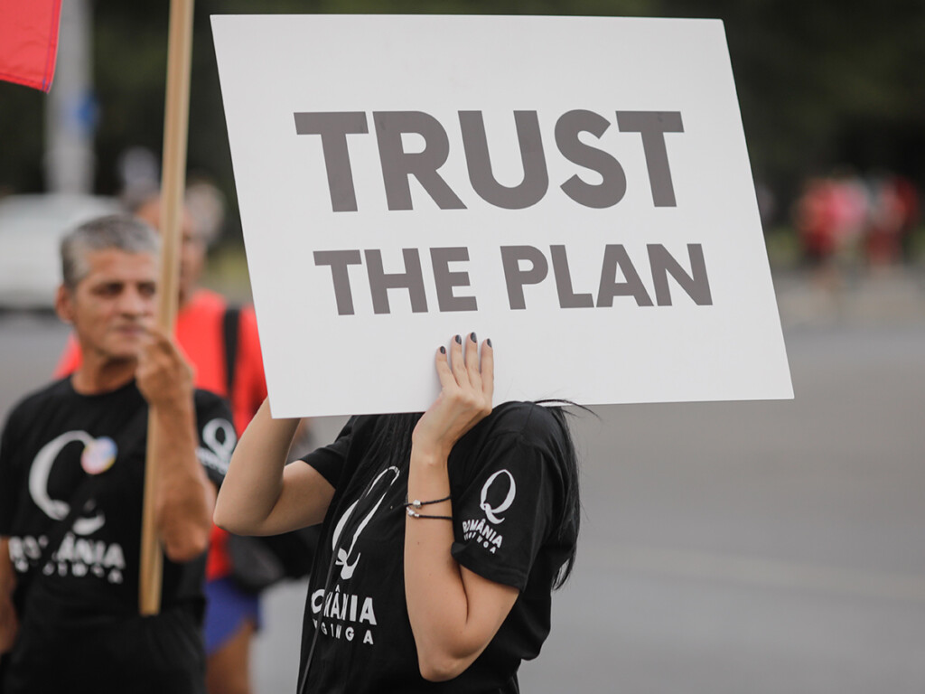 People display Qanon messages on cardboards during a political rally in Bucharest, Romania on Aug. 10, 2020. (Shutterstock)