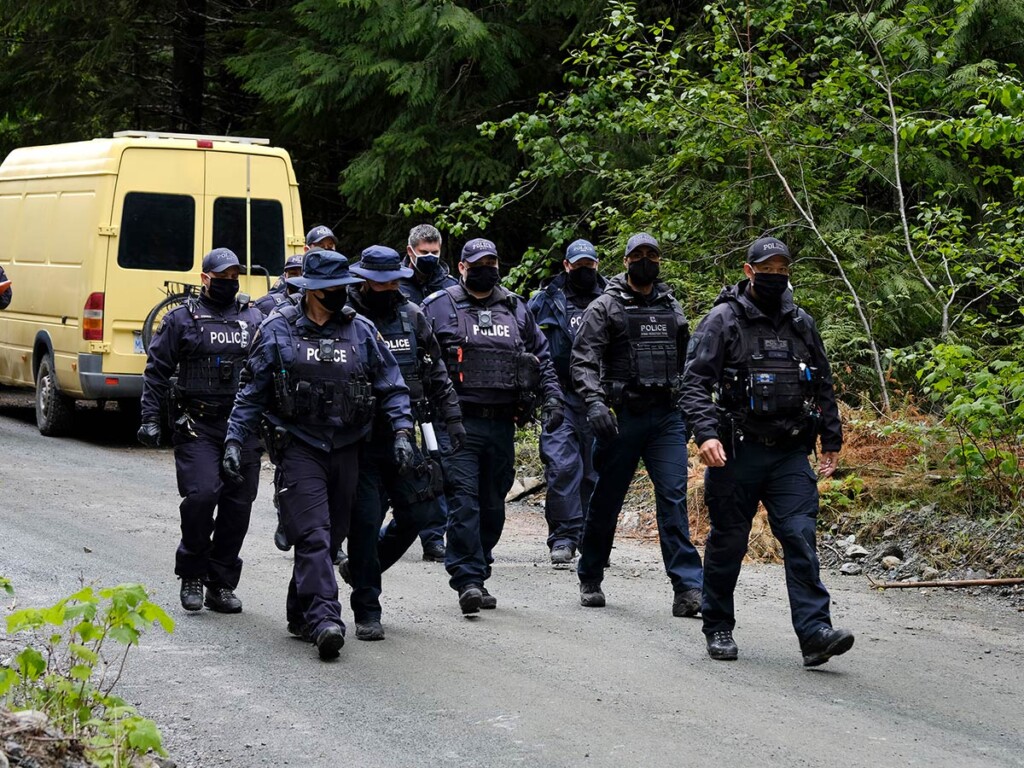 RCMP officers walk toward an anti-logging blockade in Caycuse, B.C., in May 2021