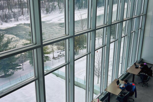 A from above view of students studying by a large glass window