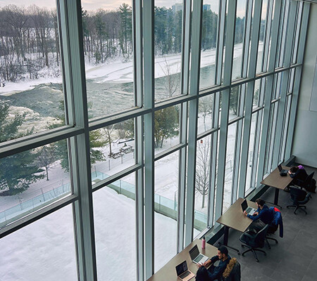 A from above view of students studying by a large glass window