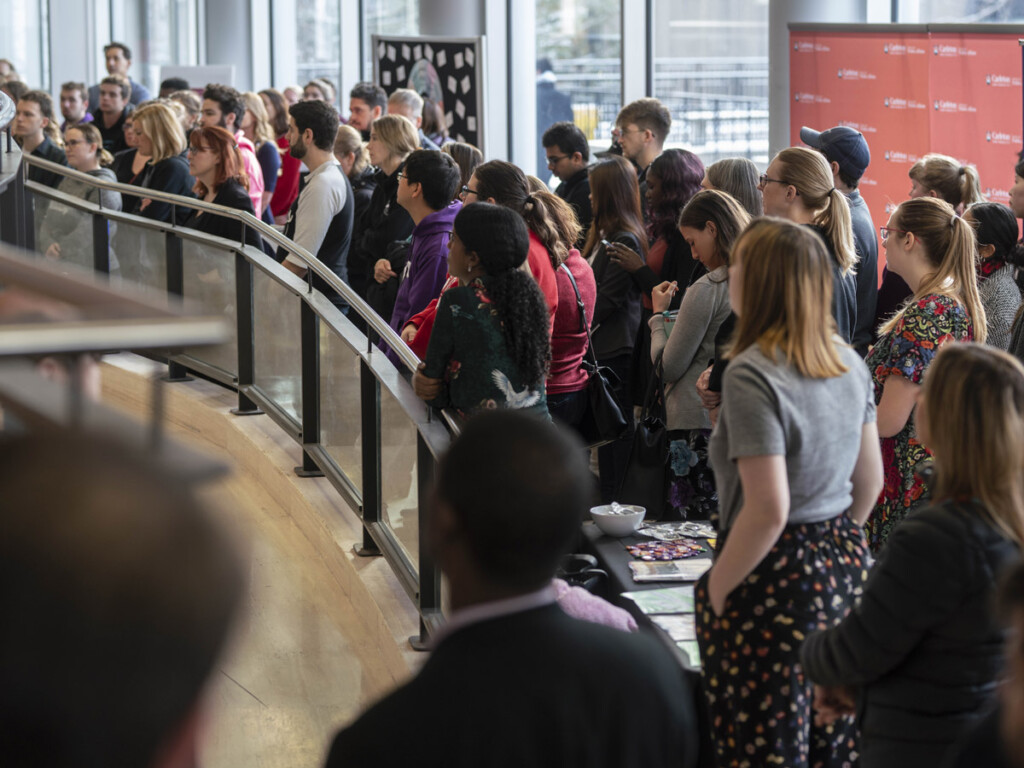 A large group of students, faculty and staff attend a vigil for victims of the Montreal Massacre in the lobby of the Tory Building.