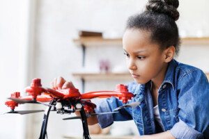 A small chuld plays with a drone.