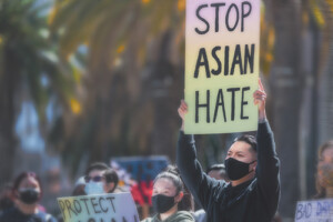 A man holds a sign that reads Stop Asian Hate