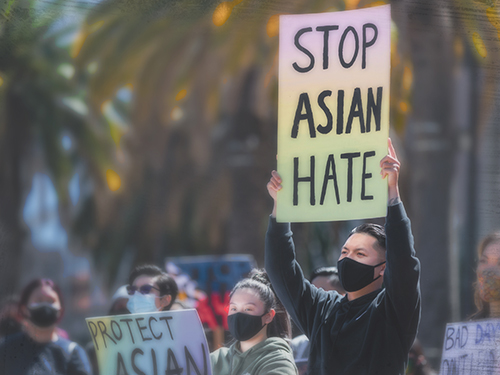 A man holds a sign that reads Stop Asian Hate