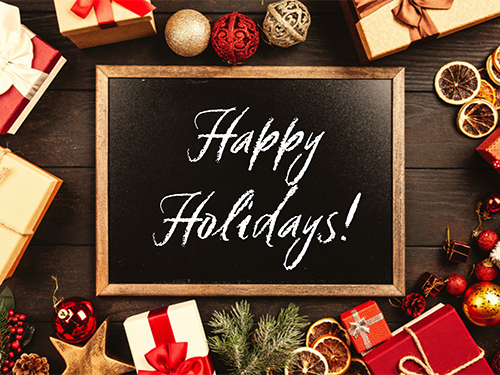 A chalkboard with the words Happy Holidays! Gifts and oranaments wrap the border of the image.
