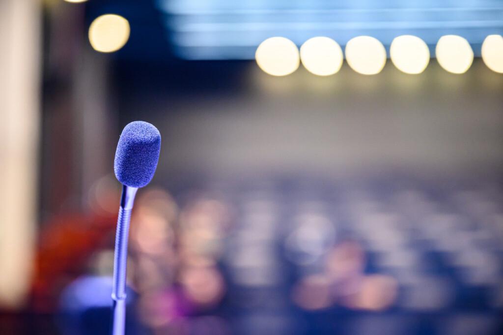 Microphone over the blurred background of an audience