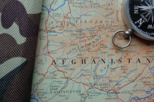 A map of Afghanistan with a compass and camouflage material depicting the Afghan War