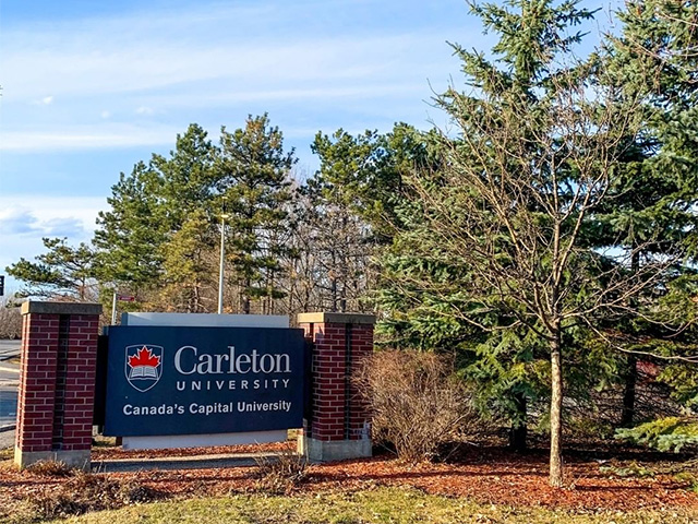 The Bronson Avenue Carleton University sign with trees in the background