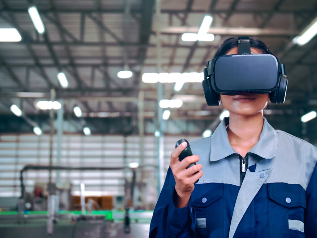 A woman in a factory wearing VR glasses to view 360-degree videos and other VR content.