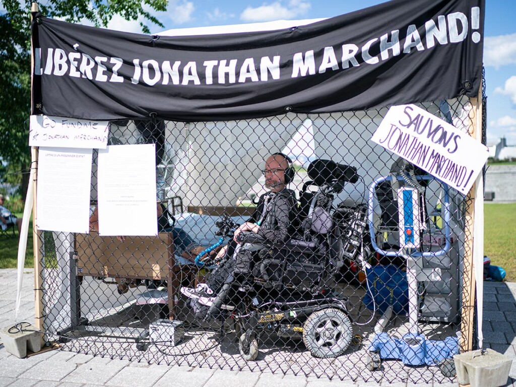Jonathan Marchand, a 43-year-old man living with muscular dystrophy, protested in a cage near the Québec legislature, in Québec City, on Aug. 13, 2020. THE CANADIAN PRESS/Mathieu Belanger