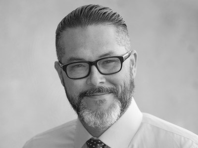 A headshot of Joshua Shepherd in black and white.