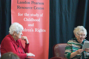 Landon Pearson speaks in front of a large pull--up banner.
