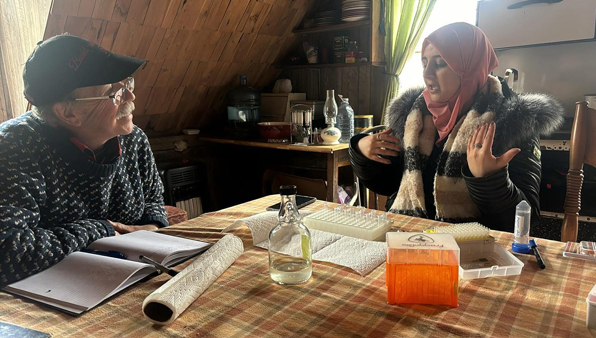 Two people having a discussion while sitting at a dining room table.