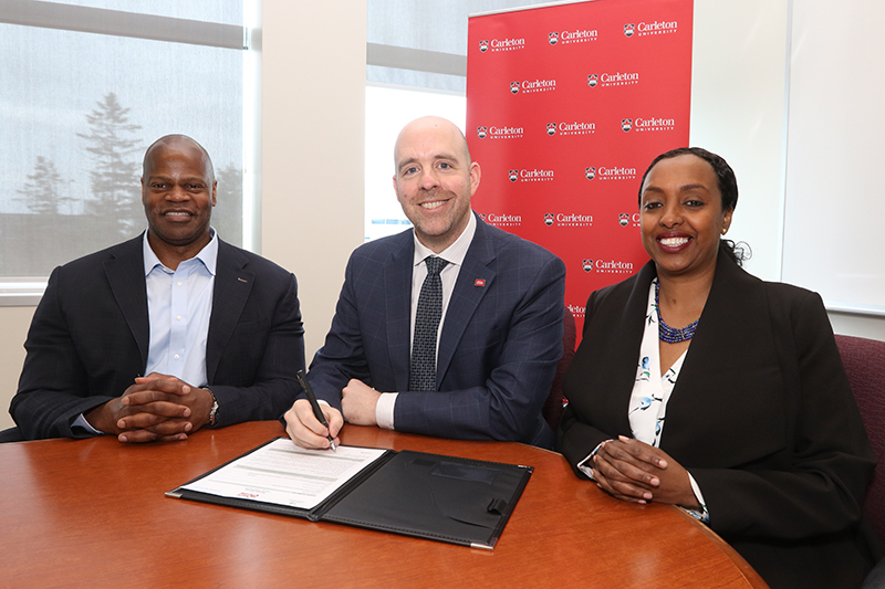 Assistant Vice-President Michael F. Charles, Carleton University President Benoit-Antoine Bacon, and Equity Services Advisor Ikram Jama