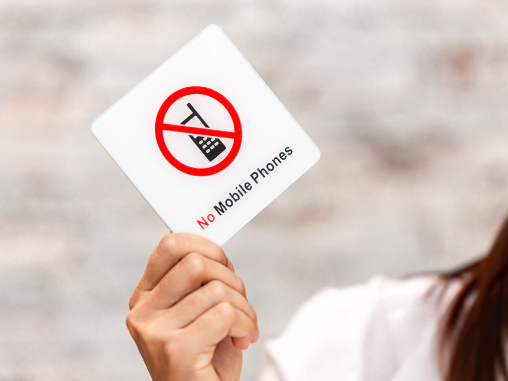 A sign with the words no mobile phones (Shutterstock)