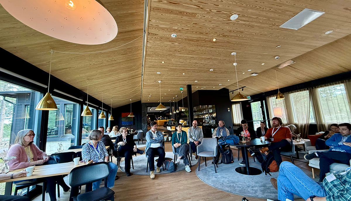 Several people seated in a large room, having a discussion.