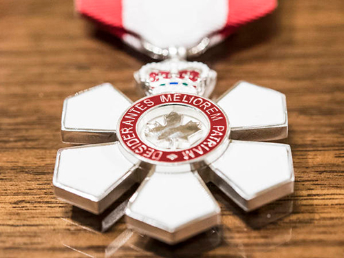 The Order of Canada insignia displayed on a wooden surface