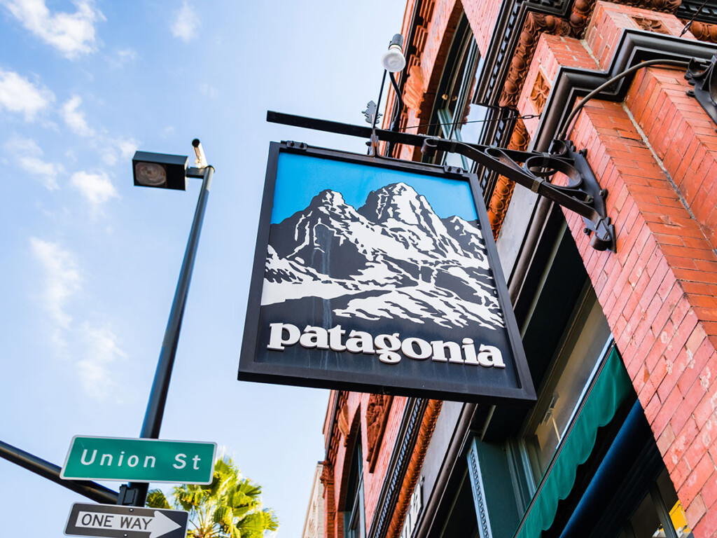A black sign connected to a brick building which has the text: Patagonia