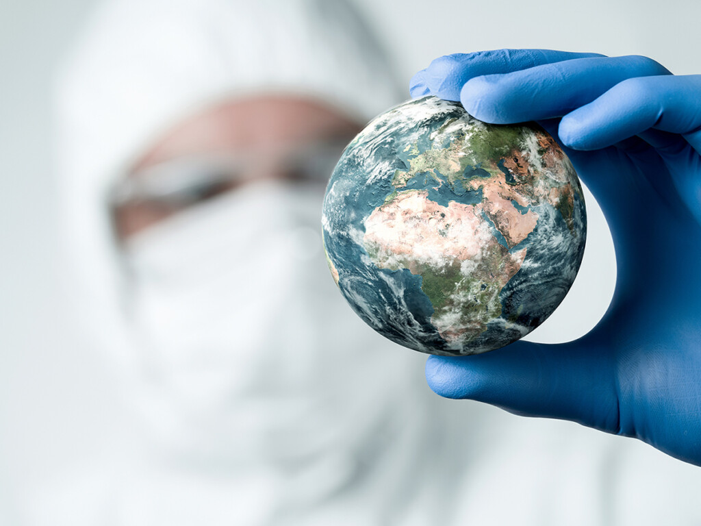 A man in a protective suit holding the globe