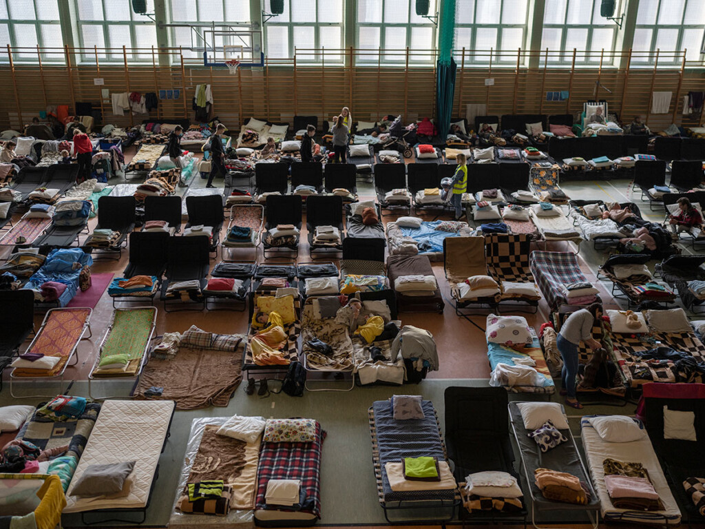 People who fled the war in Ukraine rest inside an indoor gymnasium being used as a refugee centre in the village of Medyka, a border crossing between Poland and Ukraine, on March 15, 2022. (AP Photo/Petros Giannakouris)