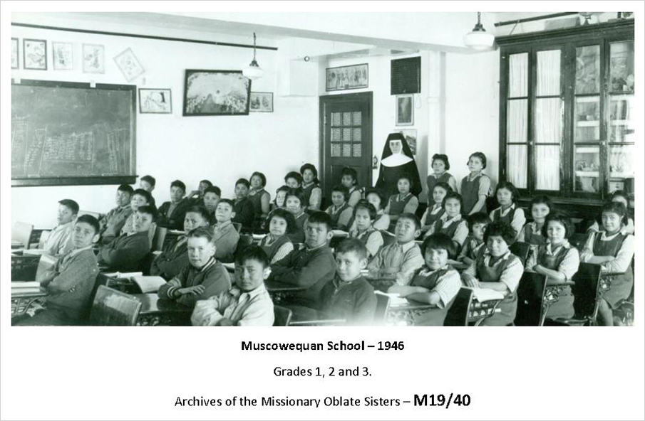 An older photo of a classroom filled with students.