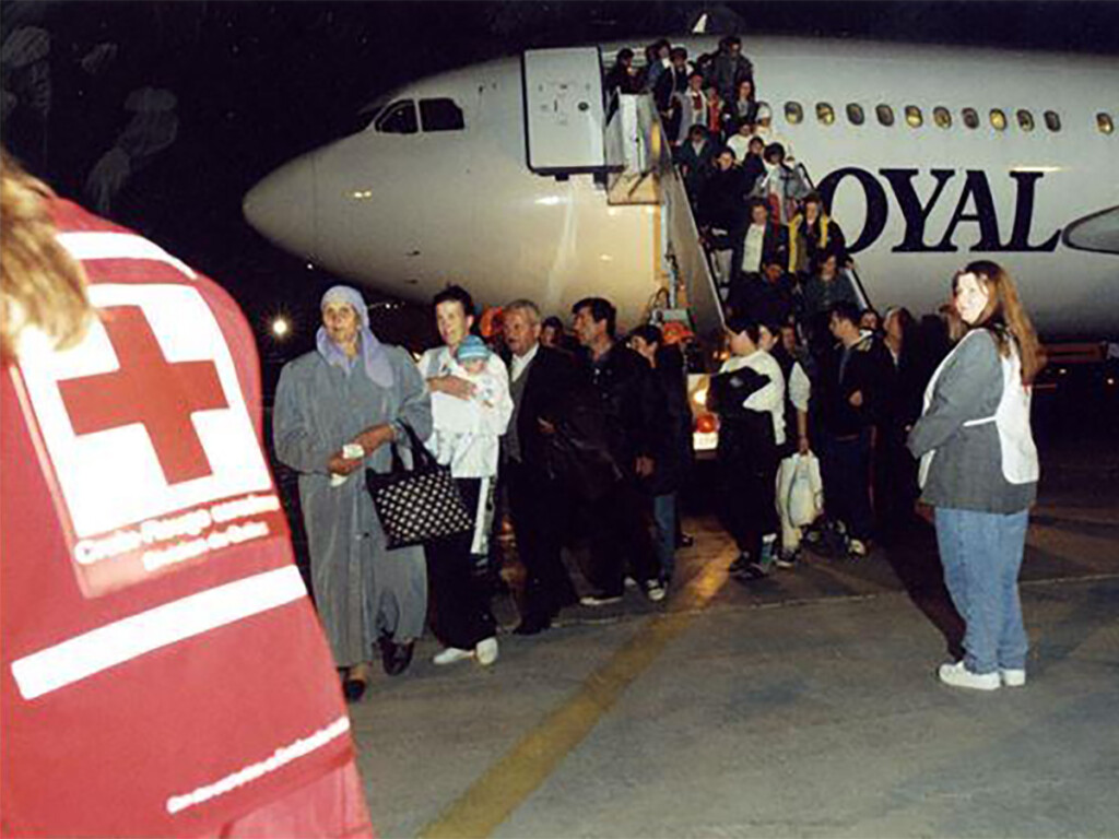 Kosovar refugees disembarking from a plane.