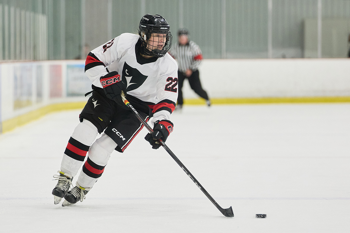 A hockey player skating with a puck.