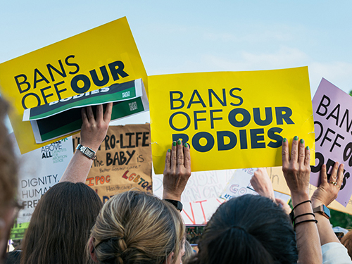 Protestors hold signs that read 'Bans Off Our Bodies'