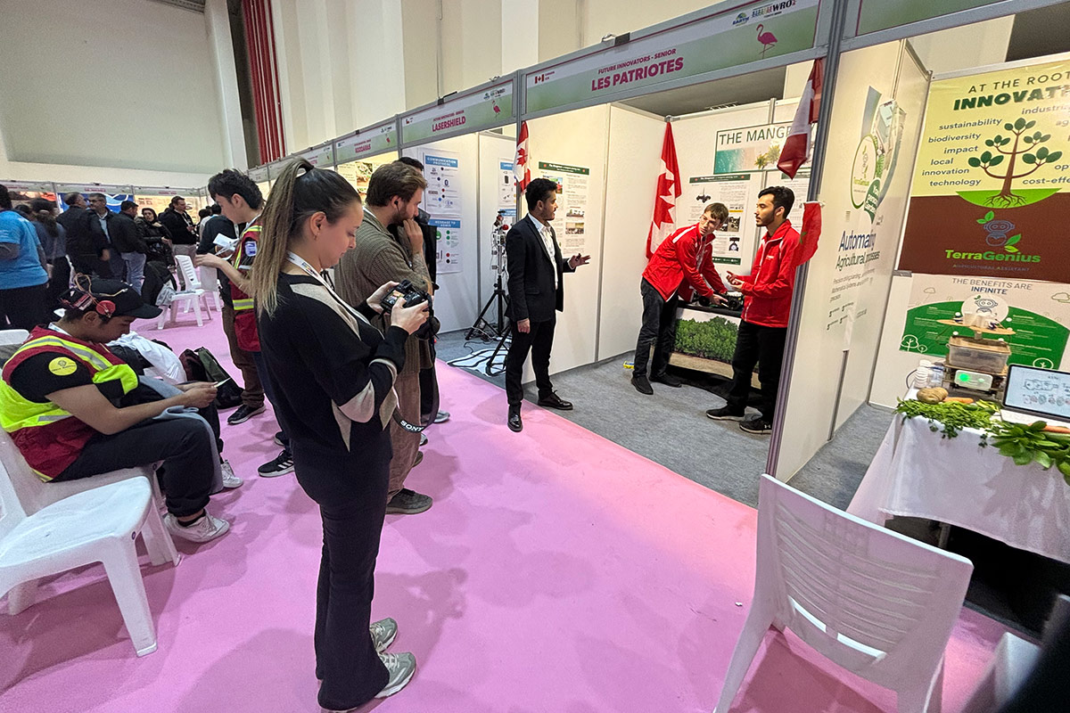 Two people giving a demonstration at a trade conference.