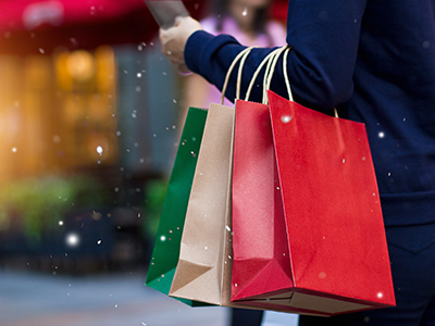 A hand carrying four gift bags.