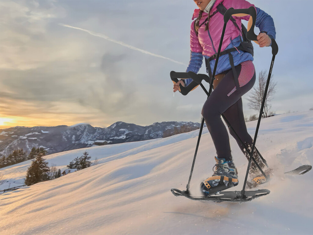 A woman using a SnowStride product on a snowy mountain.