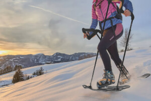 A woman using a SnowStride product on a snowy mountain.