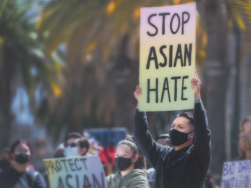 A man holds a sign that reads 'Stop Asian Hate'