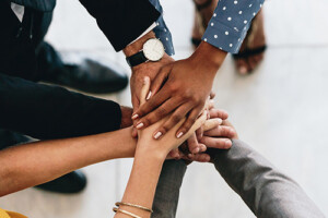 Various people putting their hands together