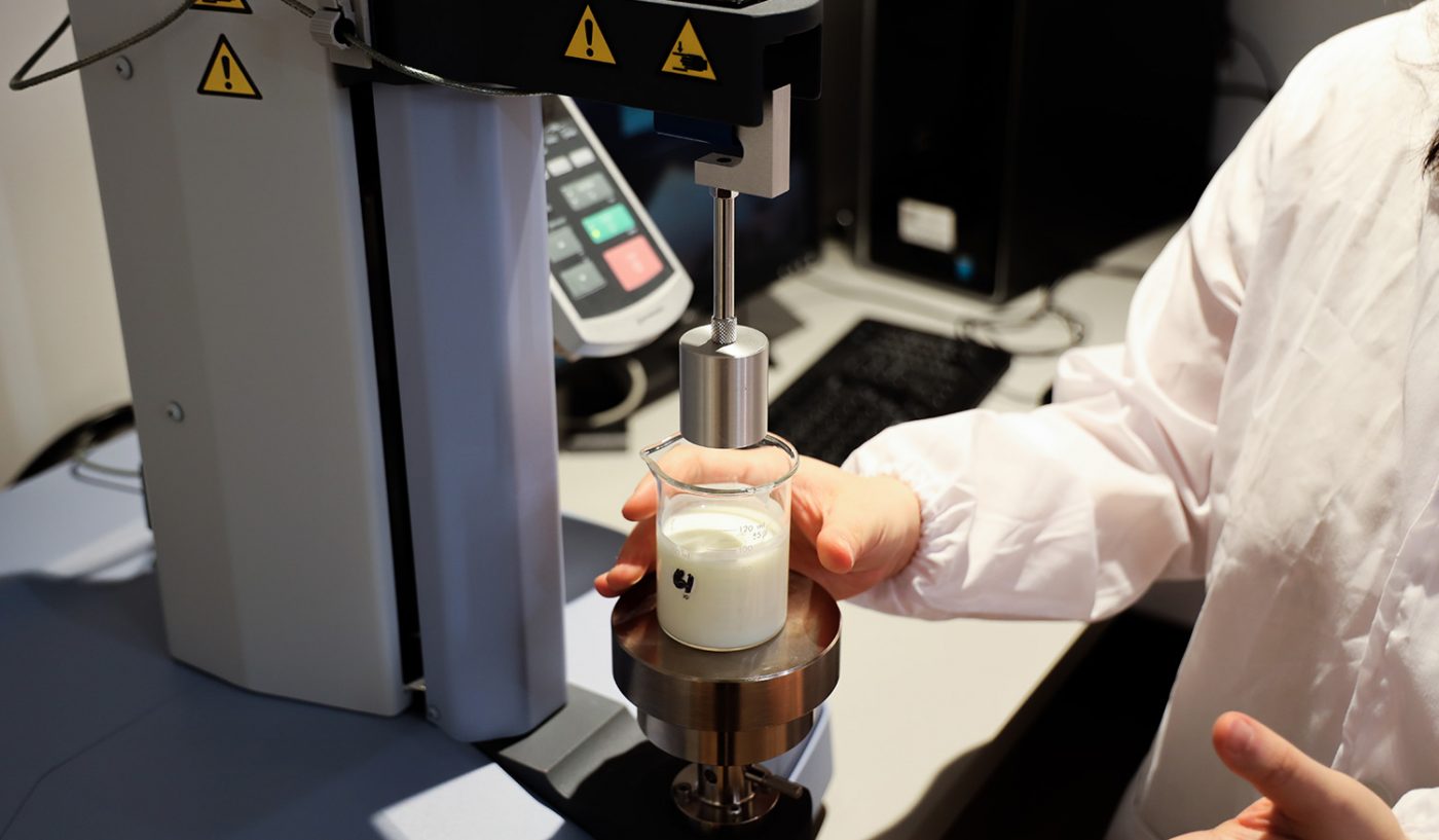 A hand holds a jar containing 3D printed food.