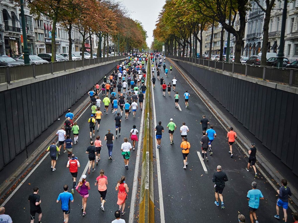 An aerial view of people running a marathon on a city street.