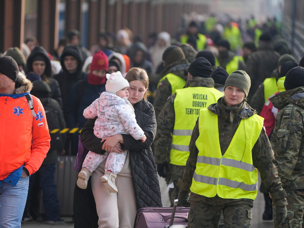 A woman holds a child as she arrives with other Ukrainian refugees at the train station in Przemysl, Poland, on Mar. 3, 2022. (AP Photo/Markus Schreiber)