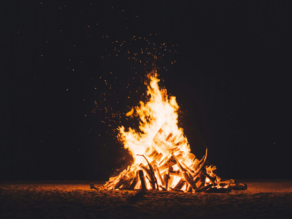 A large pile of wood on fire.