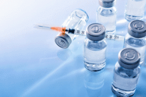 A photo of vaccines and a hypodermic needle.