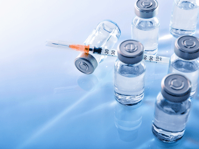 A photo of vaccines and a hypodermic needle.