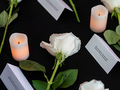A white rose flanked by white candles