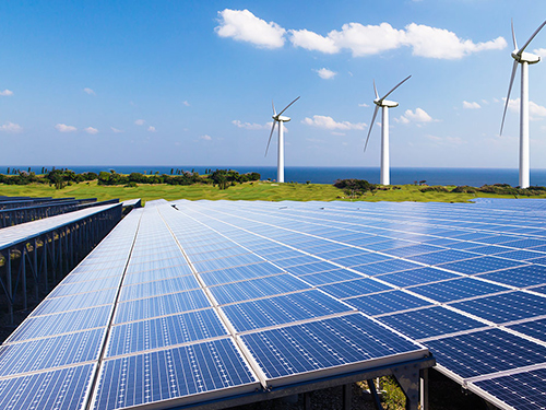 Wind turbines and solar panels along a coastline