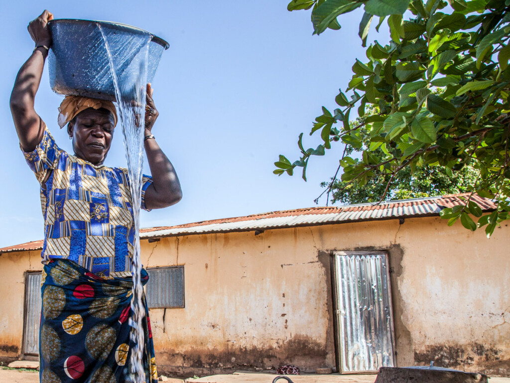 A woman pours the water that she just collected from a well in the cistern of her house in Fo-Bouré, Benin.