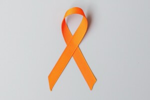 An orange ribbon on a plain background.