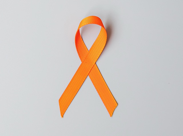 An orange ribbon on a plain background.