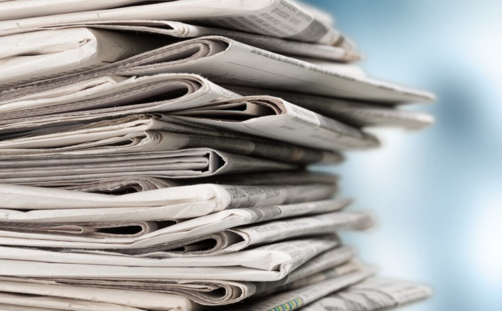 Pile of newspapers on white background