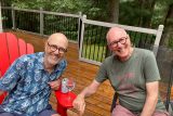 Bill and John smiling, sitting outside
