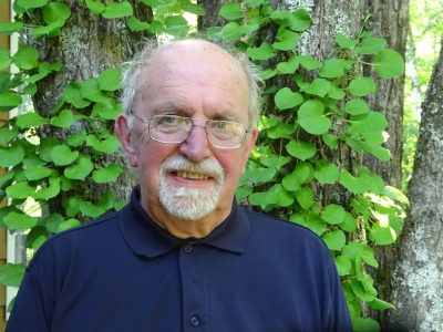 Dr. Andy Brook Outside In Front Of Green Foliage