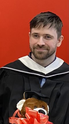 Harry Bellemare at his graduation ceremony, wearing graduation gown and collar