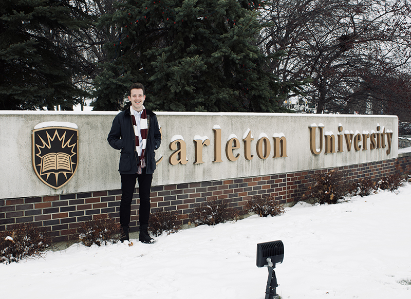 photo of Max outdoors in winter at Carleton sign